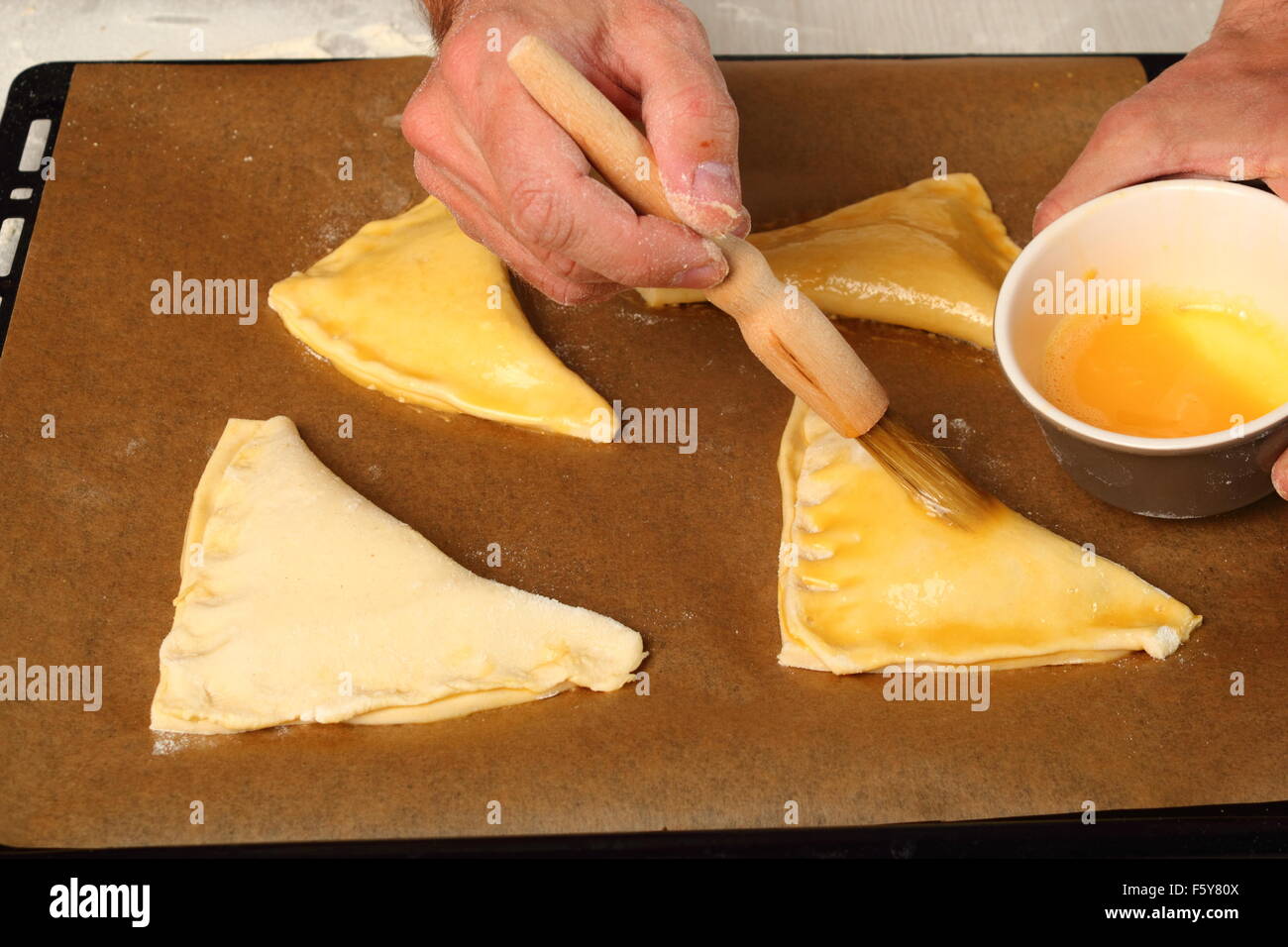 Brushing with egg glaze. Making Chocolate Croissants with Puff Pastry
