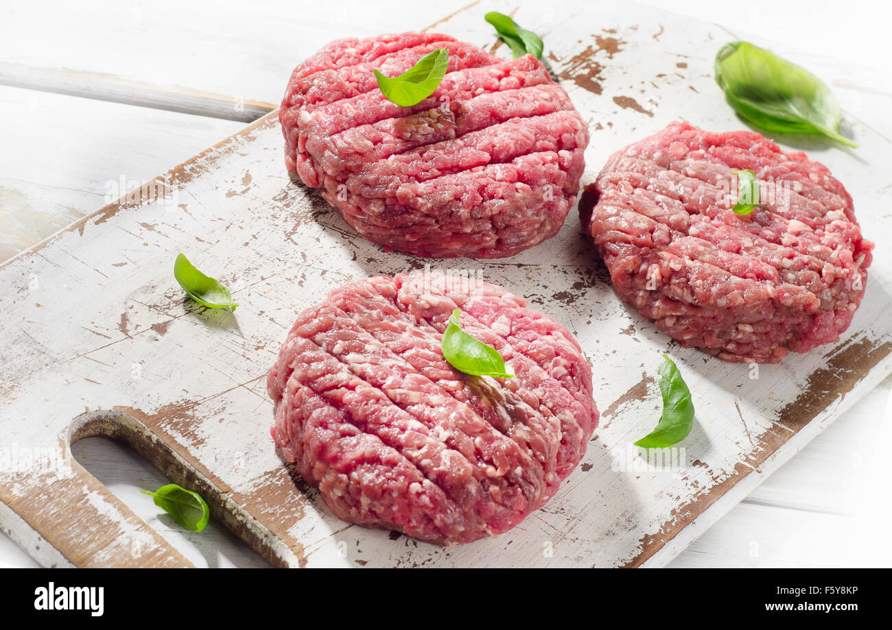 Raw Ground beef Burger steak patties on a wooden cutting board. Top