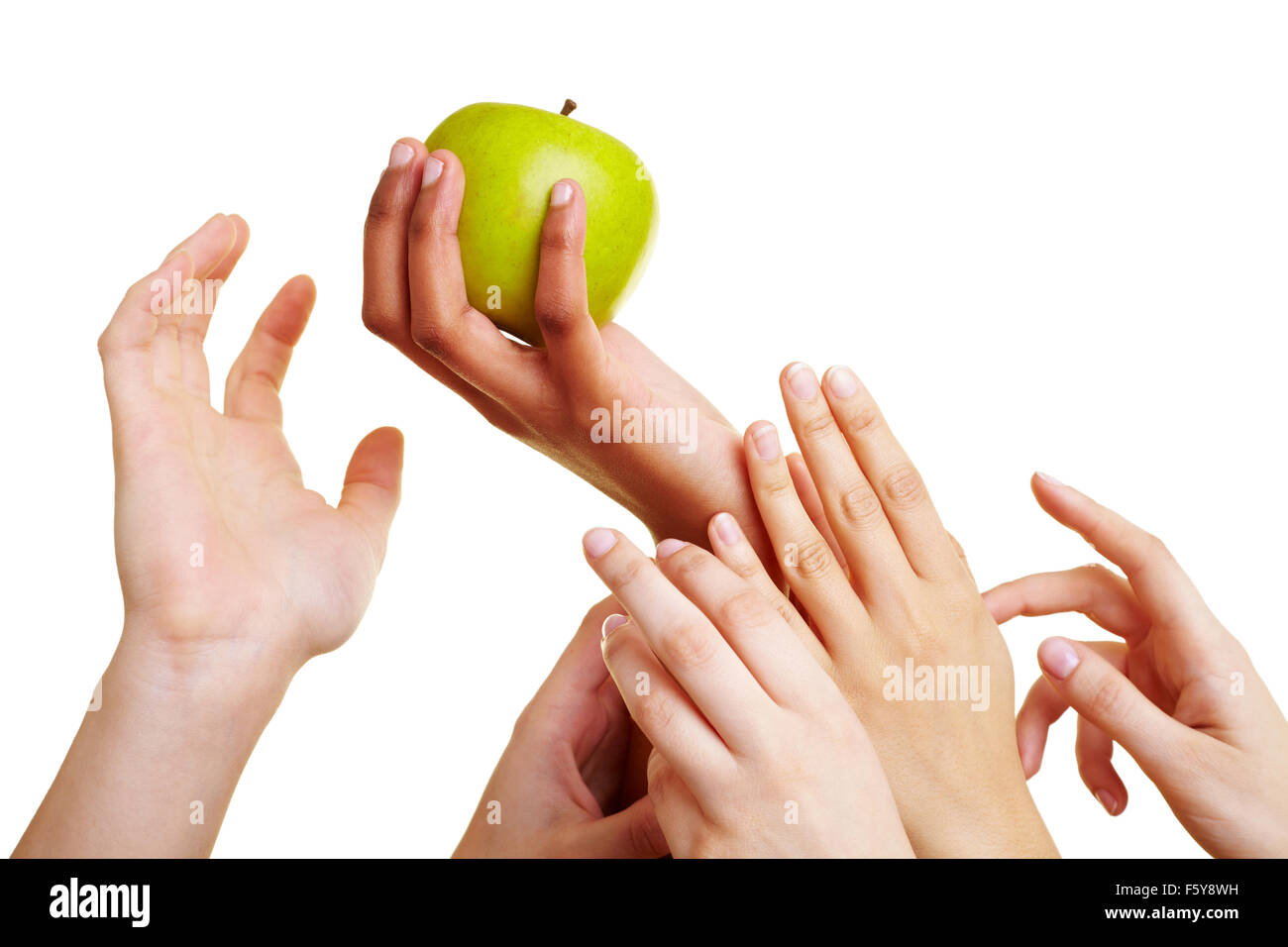 Many desperate hands reaching for a green apple Stock Photo