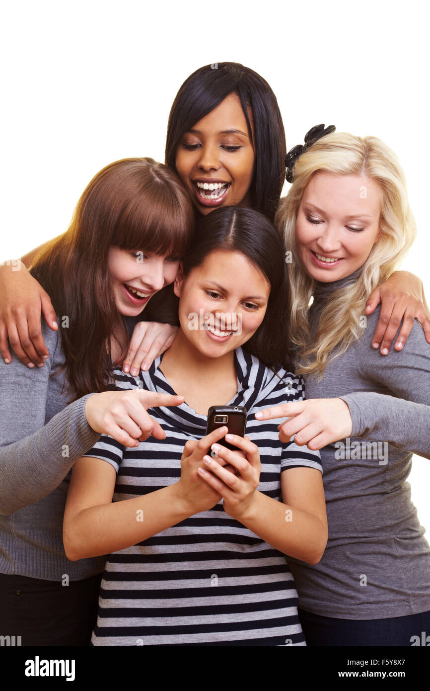 Four young women centered around a cell phone Stock Photo