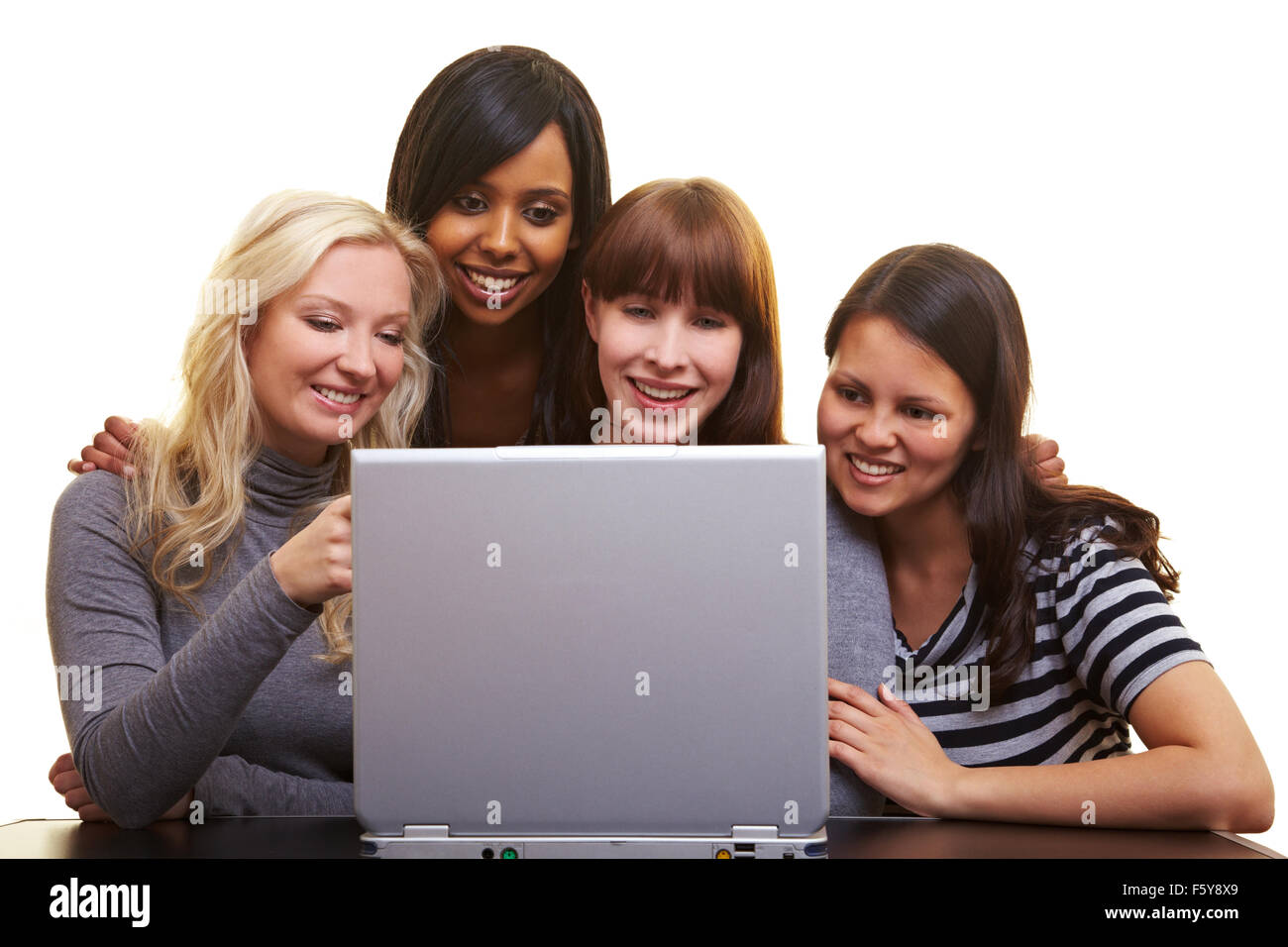 Four young happy woman centered around a laptop Stock Photo