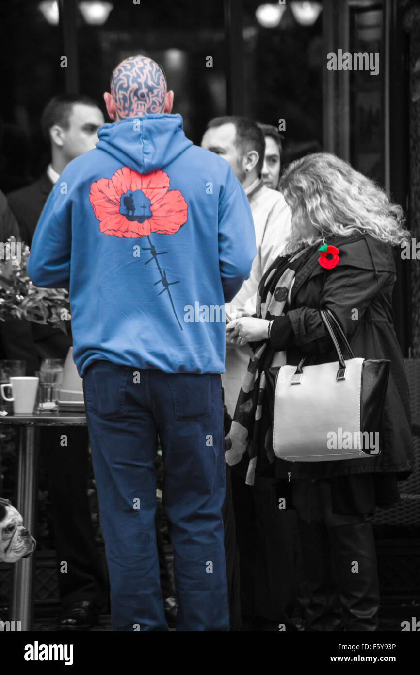 Man with tattooed bald head wearing poppy hoodie and woman wearing red poppy for Remembrance Sunday at Bournemouth Stock Photo