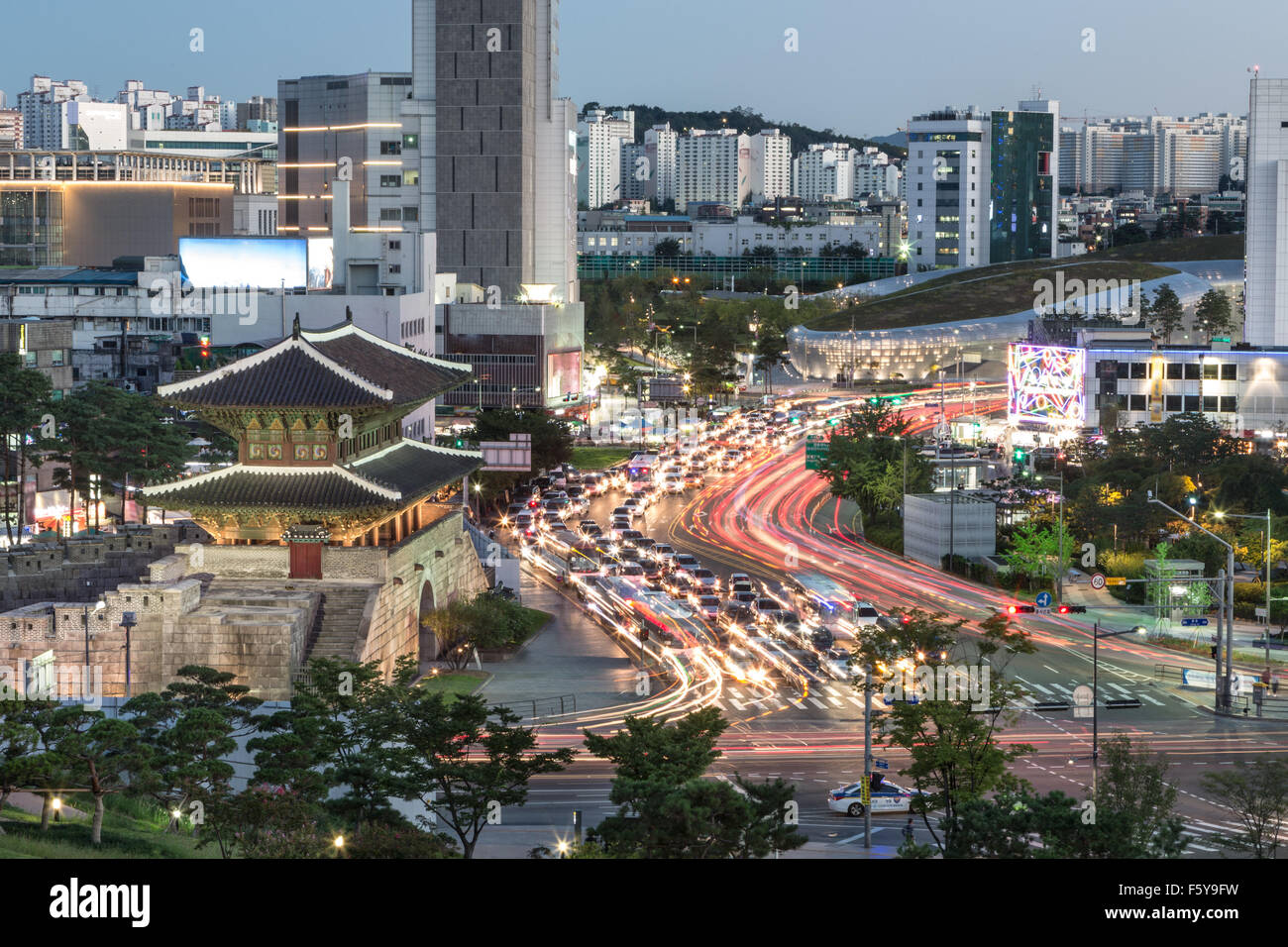 Cars rush around Heunginjimun gate (or Dongdaemun gate) which is part of the fortress wall in Seoul at dusk in South Korea capit Stock Photo