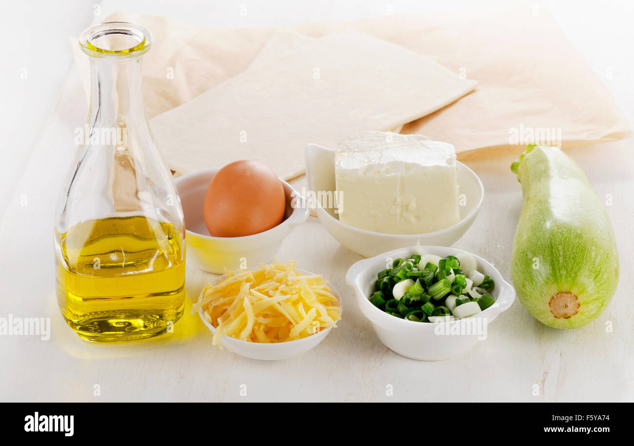 Vegetable pie ingredients. Dough, olive oil, egg, feta, cheese,vegetable Stock Photo