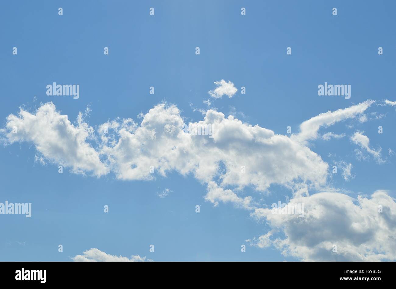 vibrant blue sky with fluffy white clouds in summer sunlight Stock ...