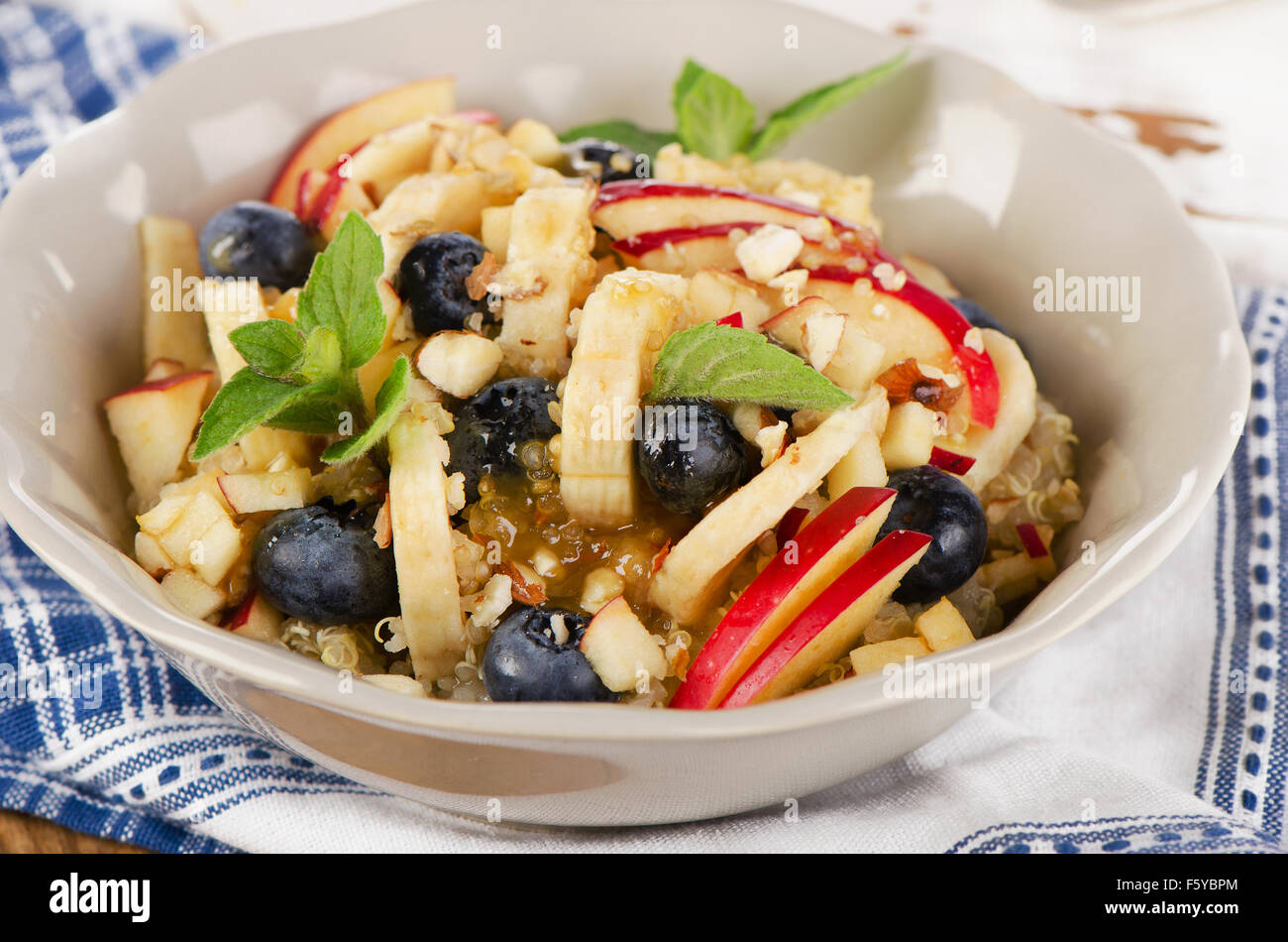 Healthy breakfast quinoa with fresh berries, banana, almond and honey. Selective focus Stock Photo