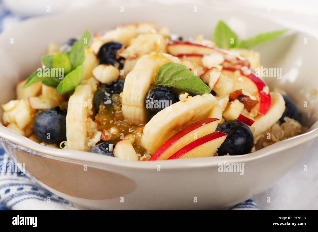 Healthy breakfast quinoa with blueberries, banana and honey. Selective focus Stock Photo