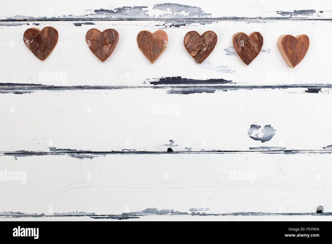objects of bark shaped as hearts on vintage wooden background Stock Photo