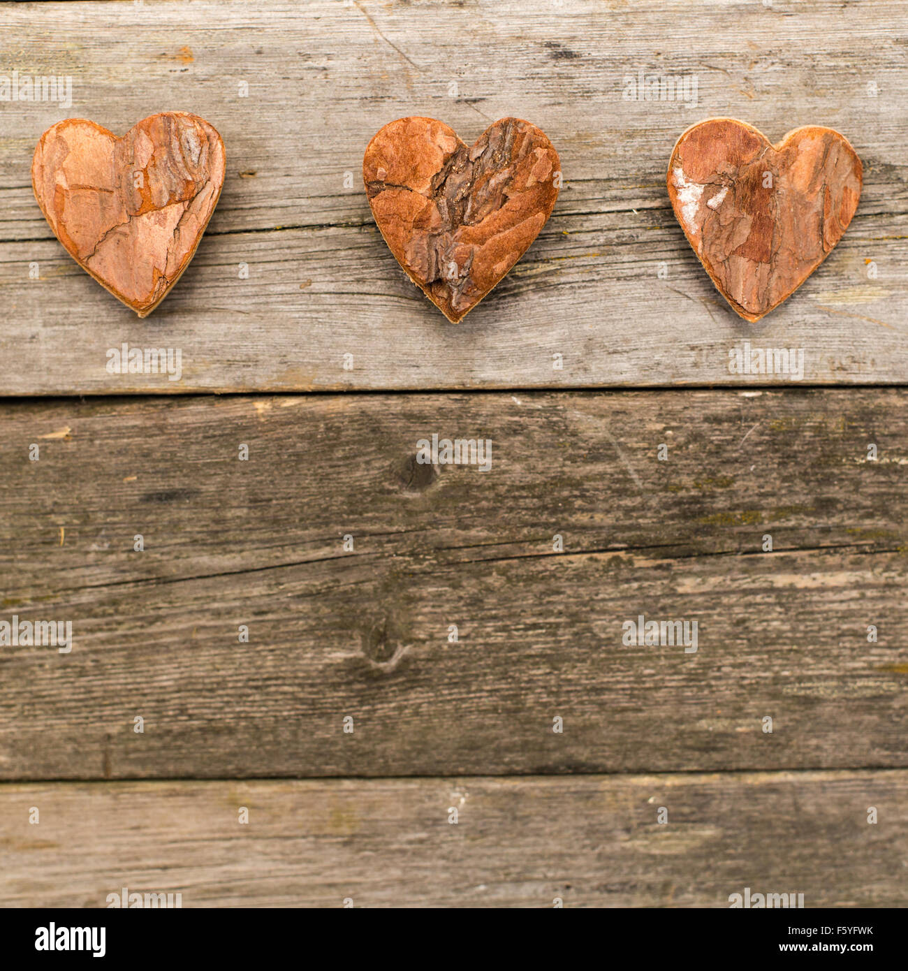 three hearts of bark on a wooden background with copy space Stock Photo