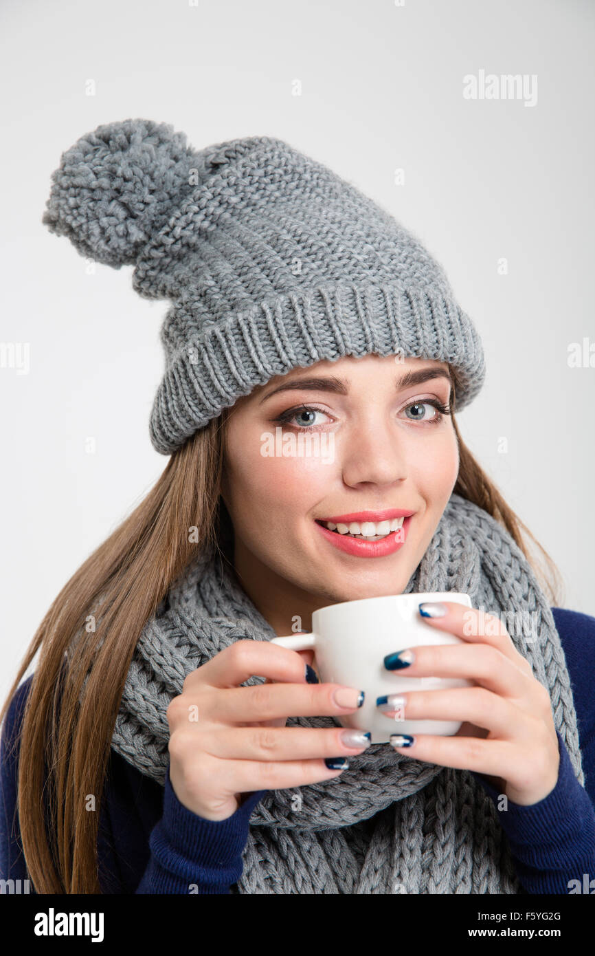 Portrait of a smiling woman in winter cloth drinking coffee isolated on ...