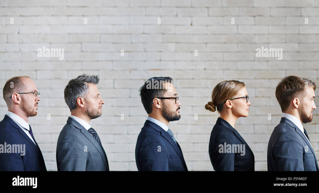 Serious business team standing in a row Stock Photo - Alamy
