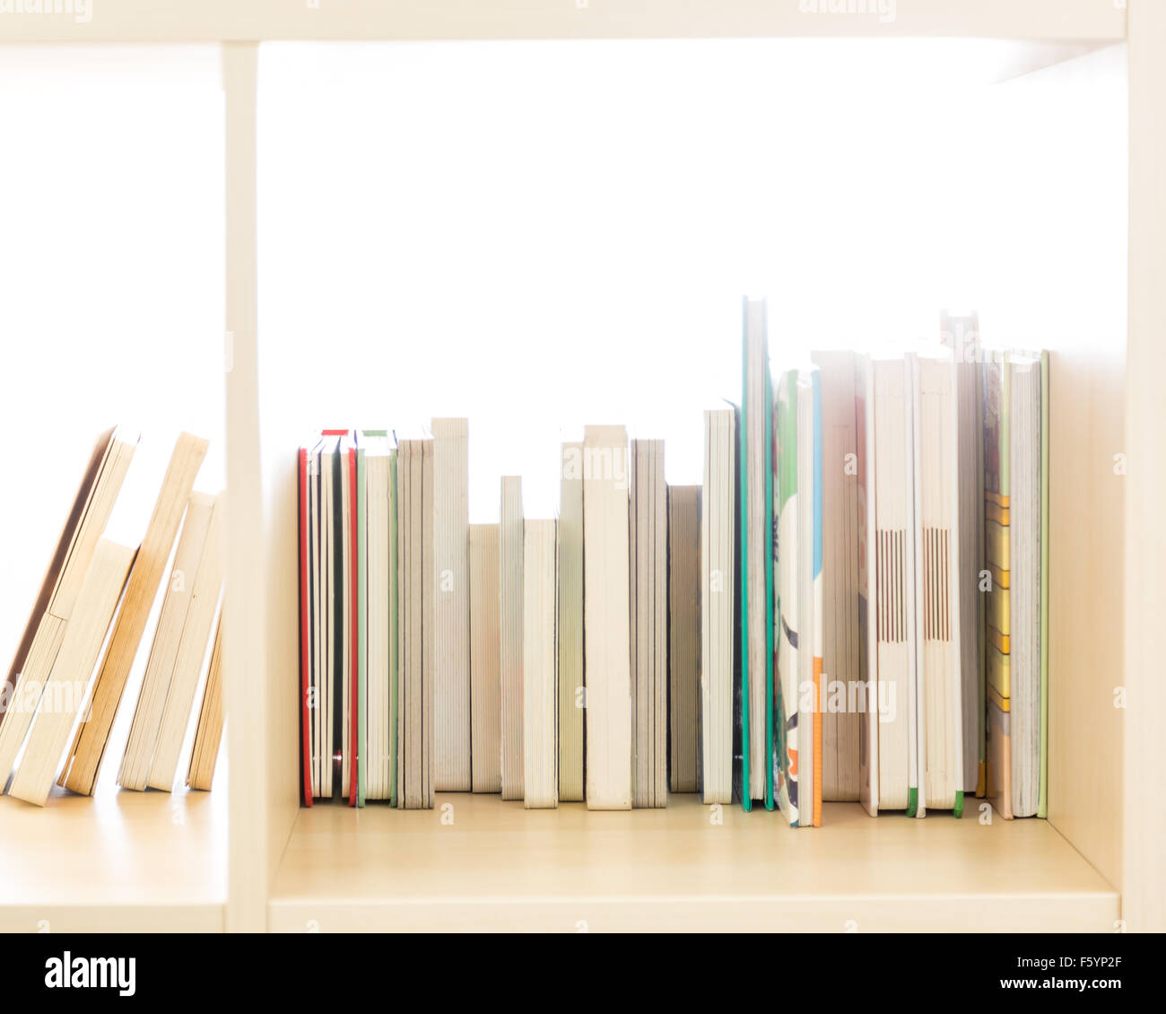 Row of books in a wooden bookcase Stock Photo