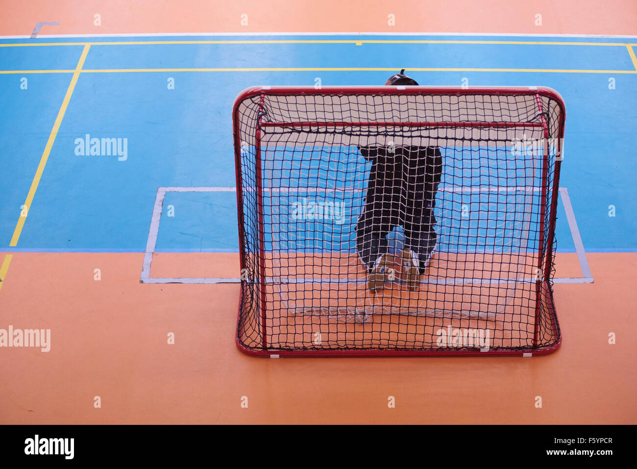 Children boys schoolchildren playing floorball (floor hockey) match in