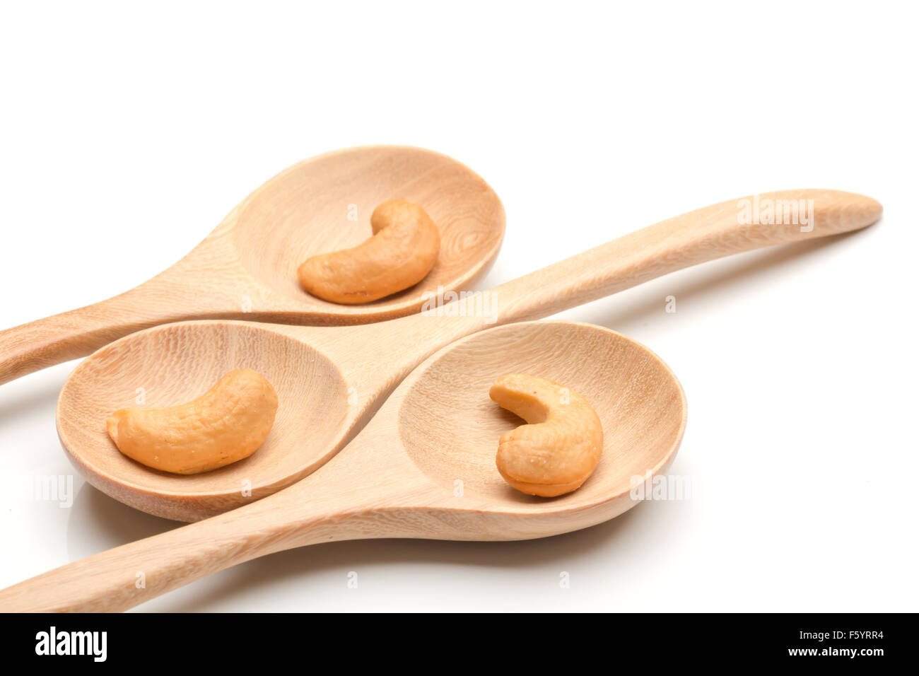 cashew nuts in spoon on wood arrange on white background Stock Photo