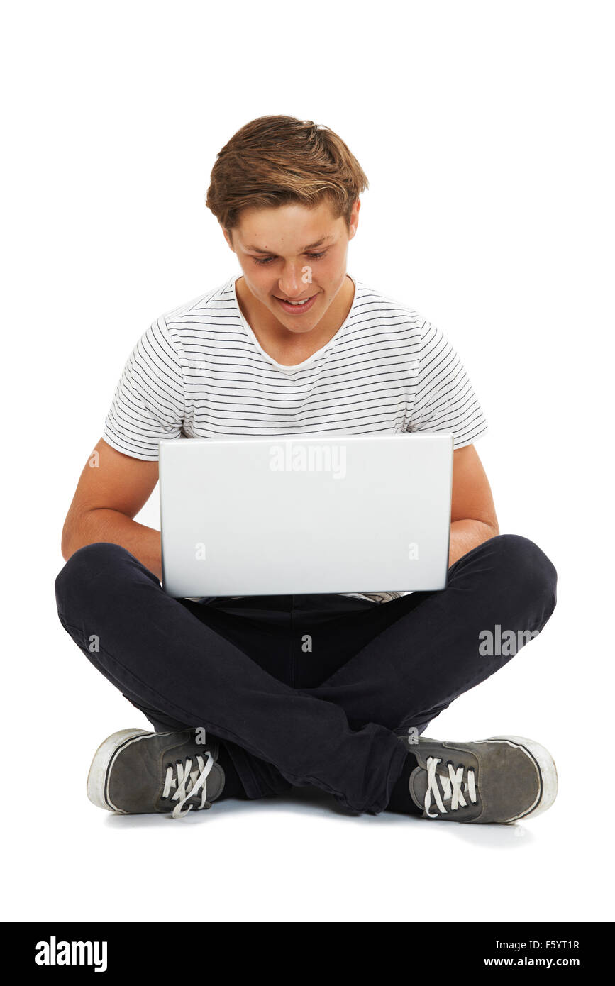 Studio Shot Of Teenage Boy Using Laptop Stock Photo