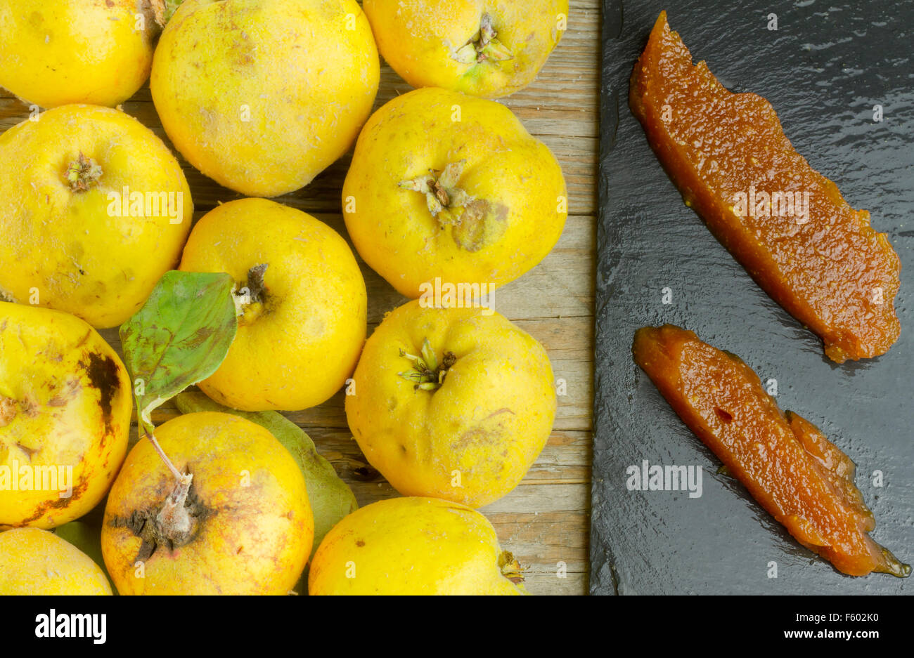 Spanish quince paste on a slate plate with quince fruits on wooden
