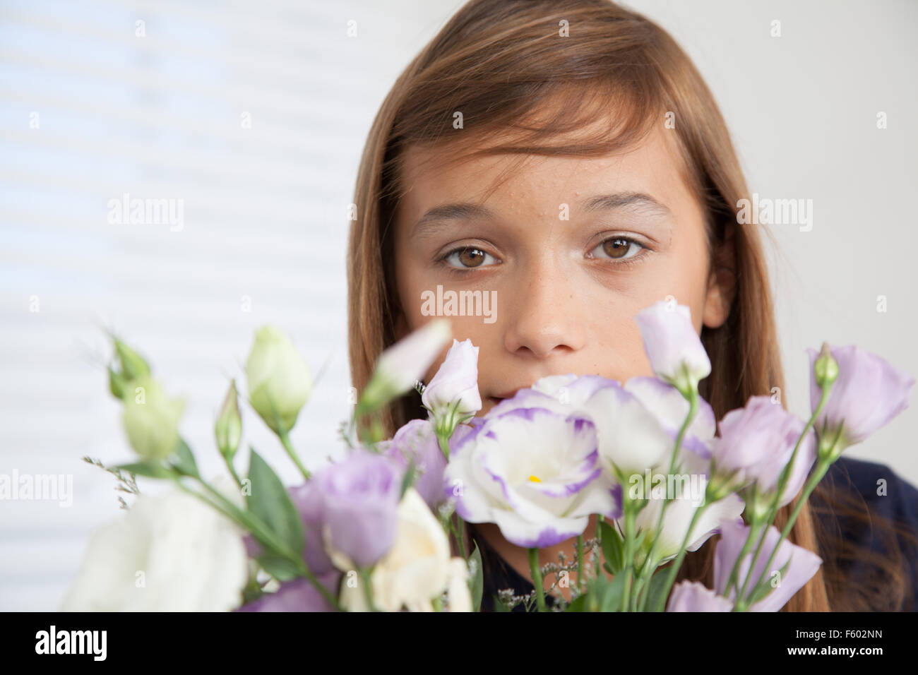Pretty girl smelling the flowers Stock Photo - Alamy