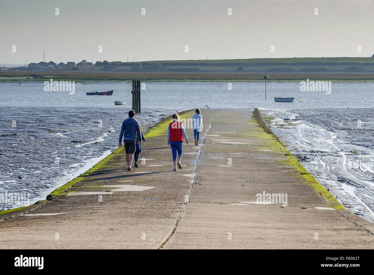 A family walking along the slipway on Two Tree Island in Essex. Stock Photo