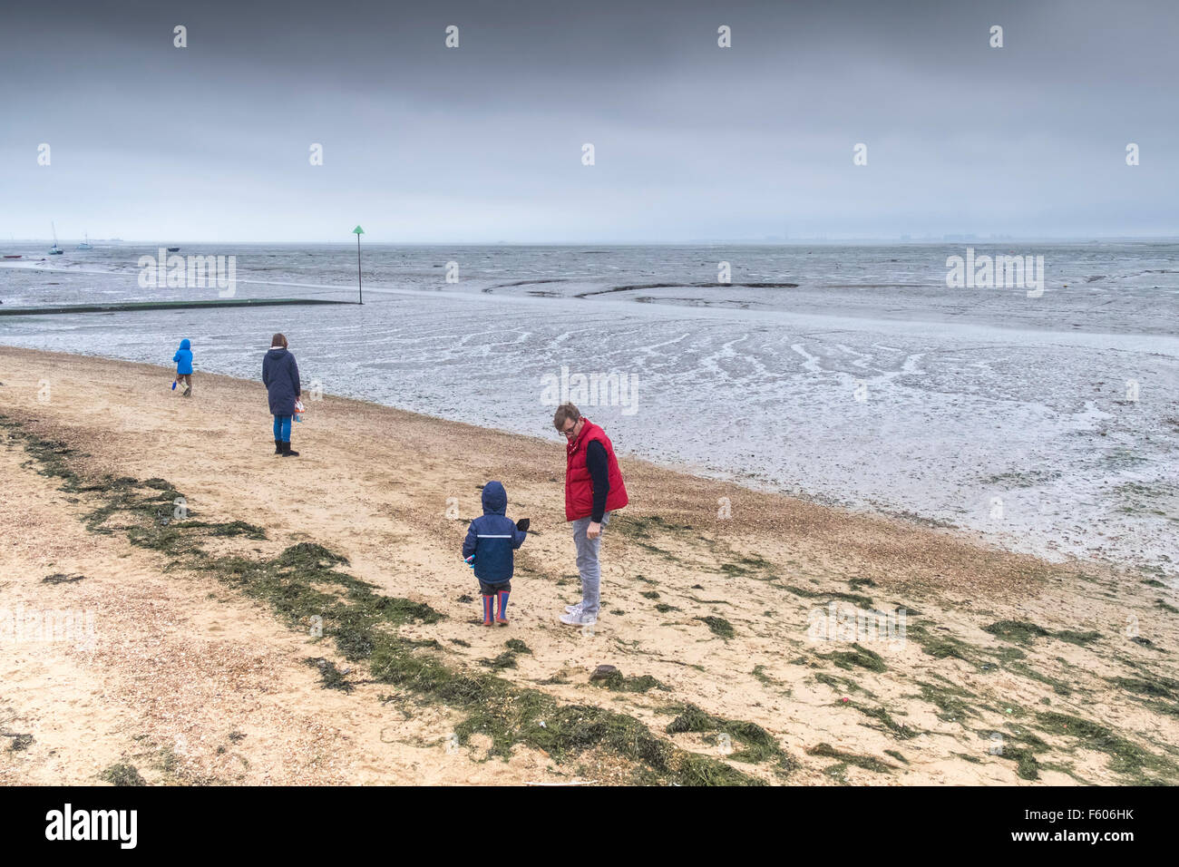 A family brave the cold weather on Bell Wharf beach in Leigh on Sea, Essex. Stock Photo