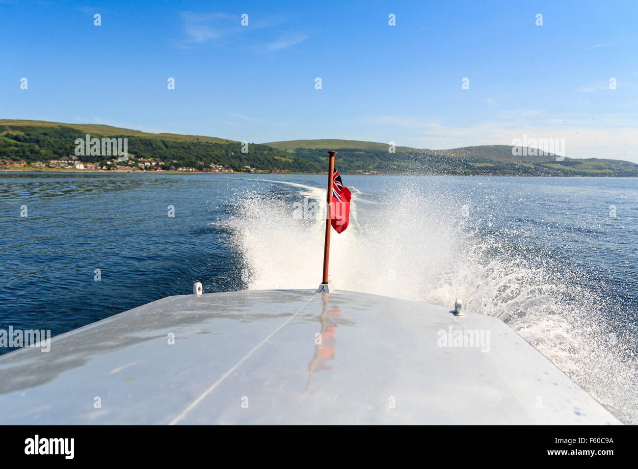 Jack Rides In A Motorboat Against A River Current Spray and waves behind fast motorboat with national flag of United Kingdom UK of Great Britain