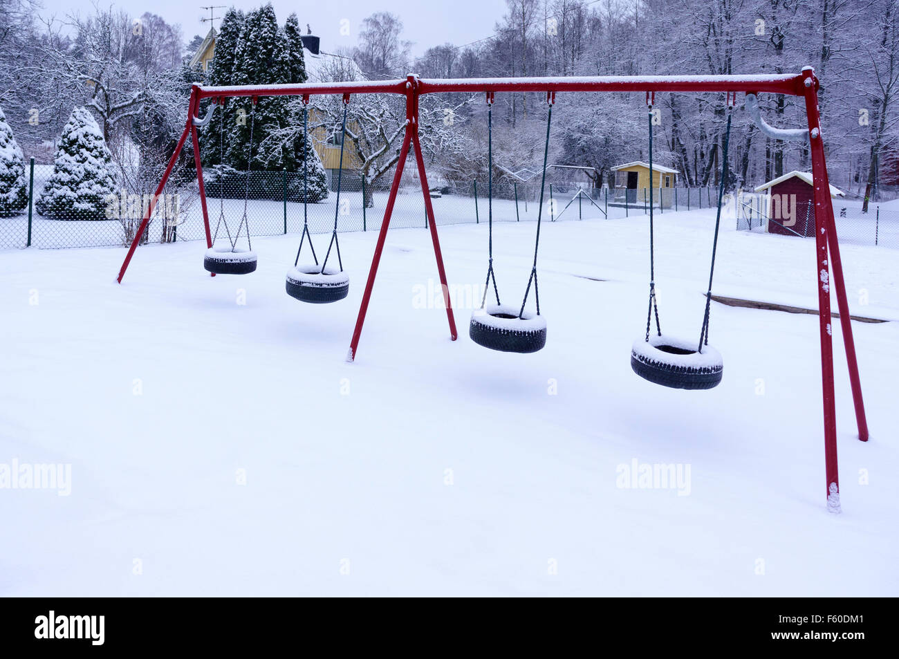 Kids outdoor playground swings covered in snow Model Release No