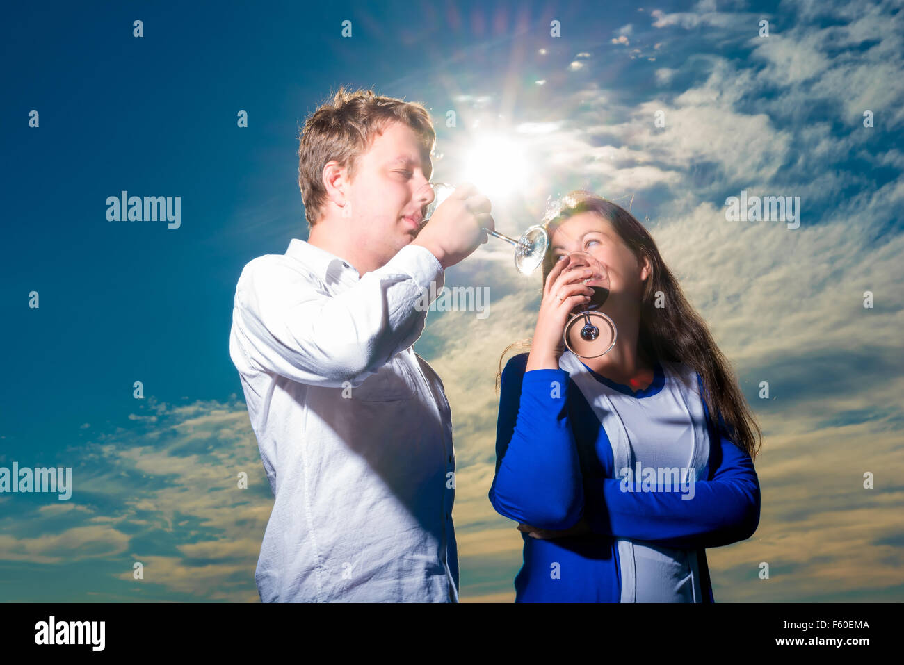 Young couple drinking red wine shot against the sky Stock Photo