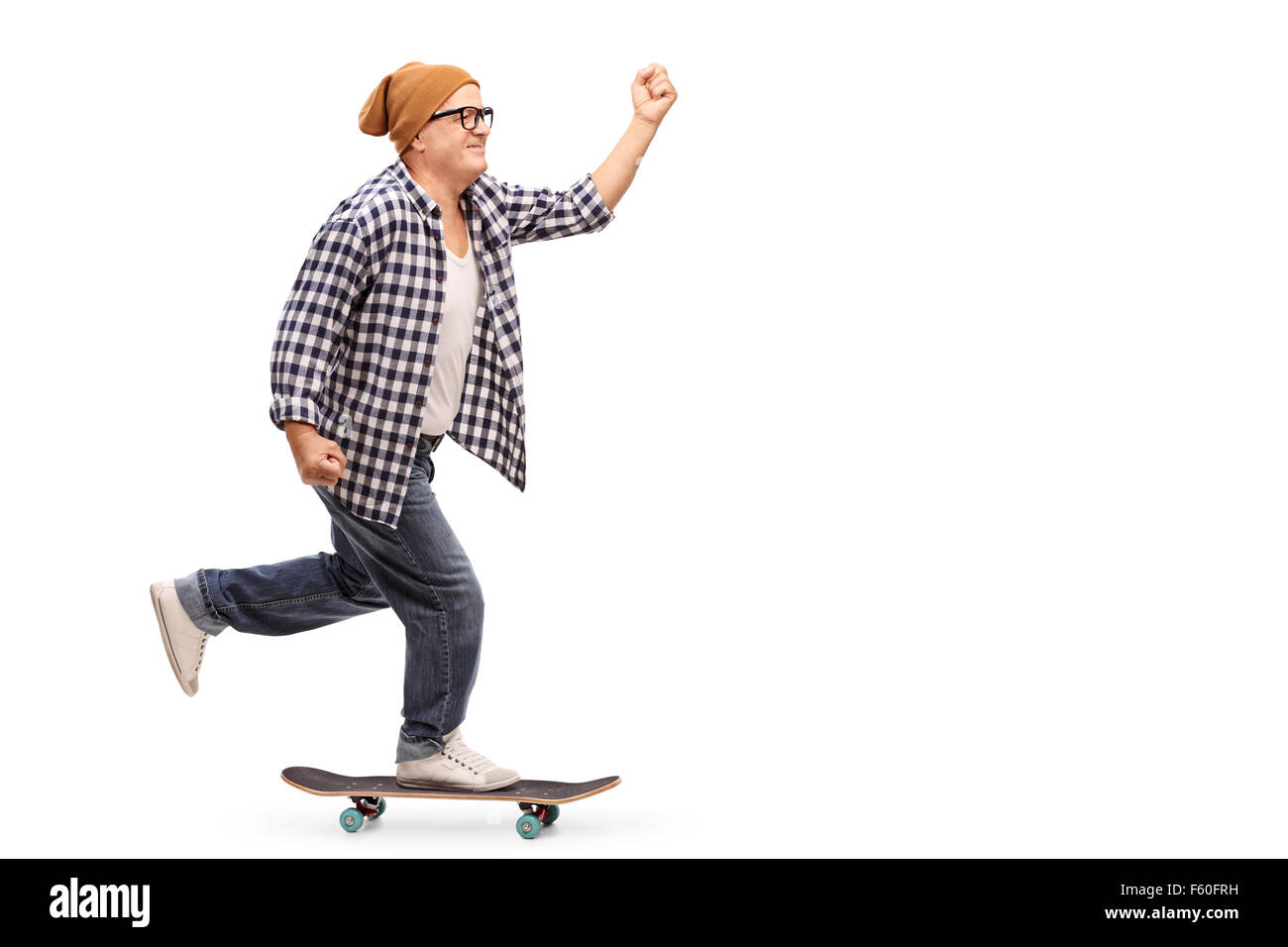 Profile shot of a joyful senior skater riding a skateboard isolated on white background Stock Photo