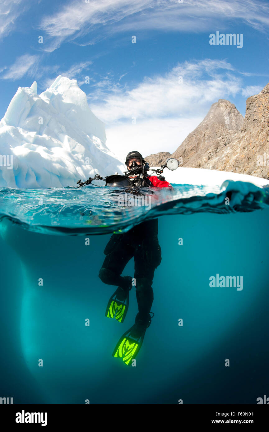 Over/under shot of diver and iceberg Stock Photo