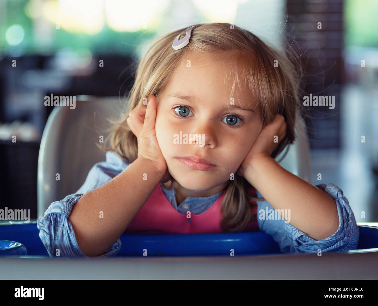 Portrait of pensive little girl propping head in her hands Stock Photo ...