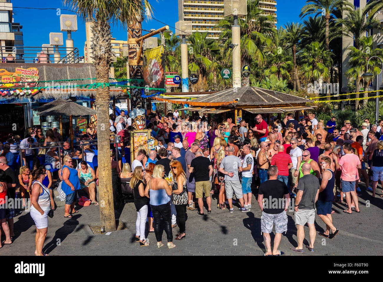 Benidorm, Spain. 10th November, 2015. British tourists in the resort for the annual Fiesta enjoy the hot autumn weather with cool drinks in the seafront bars. Crowds outside the beachfront Tiki Bar. Stock Photo