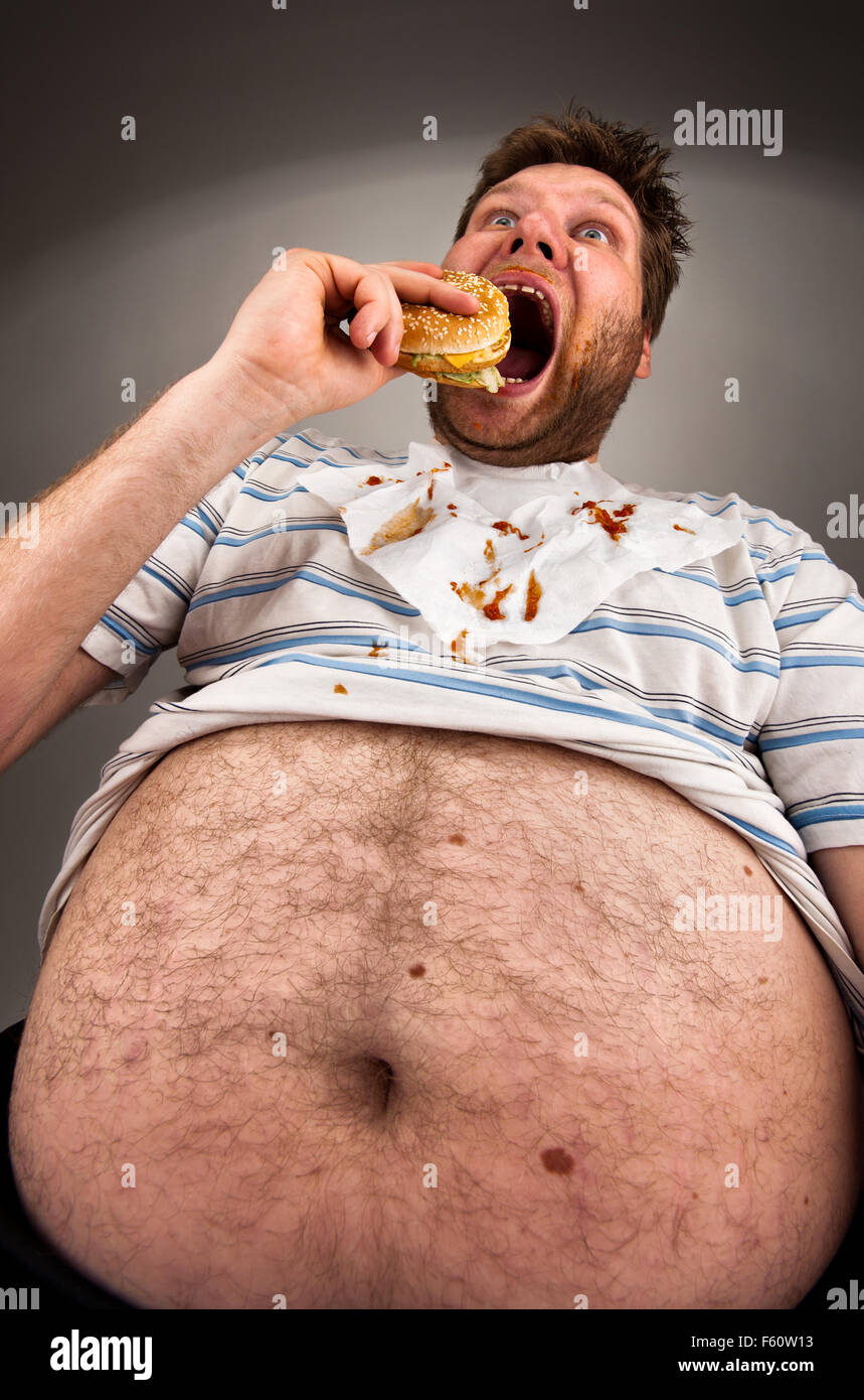 Portrait of expressive fat man eating burger Stock Photo