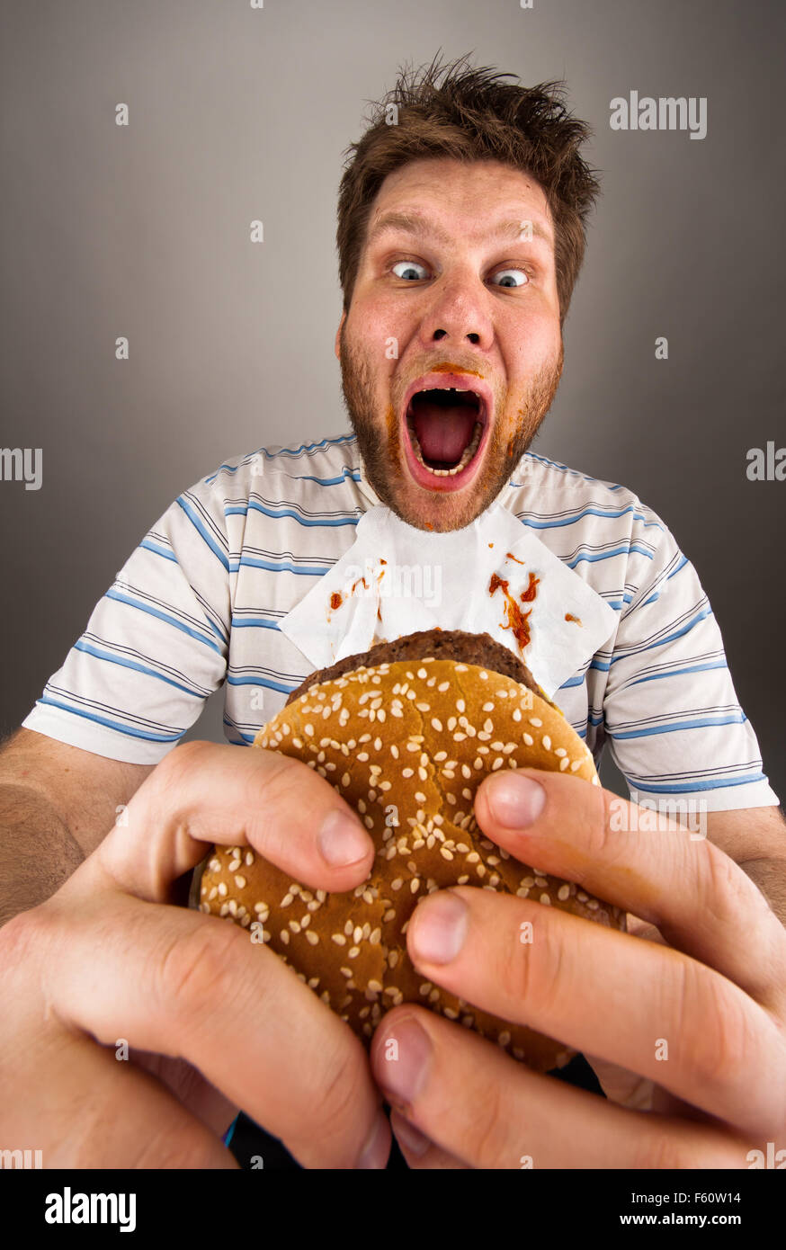 Portrait of expressive fat man eating burger Stock Photo