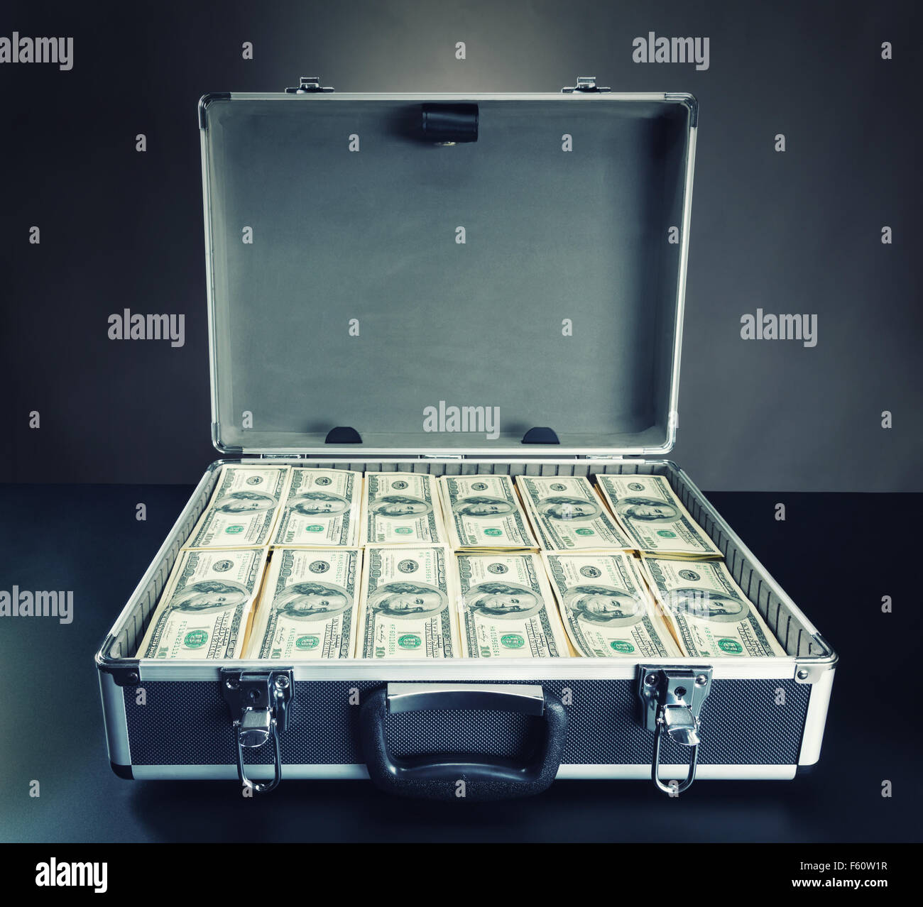 Open case full of dollar cash on gray background Stock Photo - Alamy