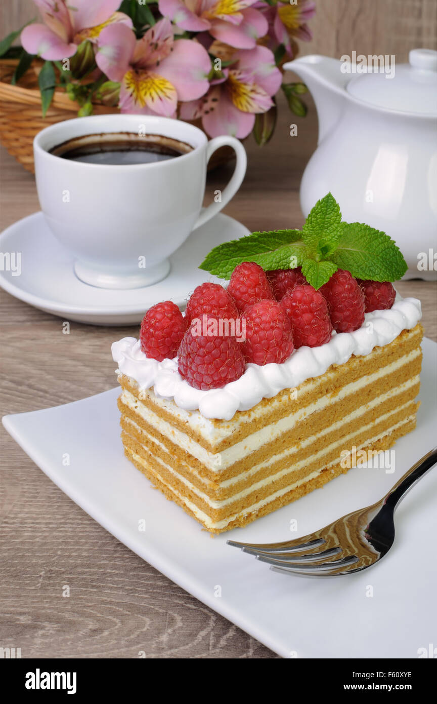 Piece of honey cake with whipped cream and raspberries Stock Photo