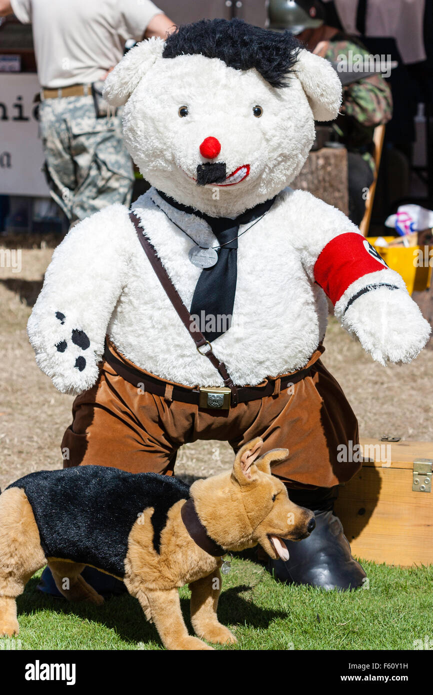 War and Peace show. Comic parody. Large stuffed toy dog standing with Adolf Hitler looks and uniform with pet 'blondie' in front. Stock Photo