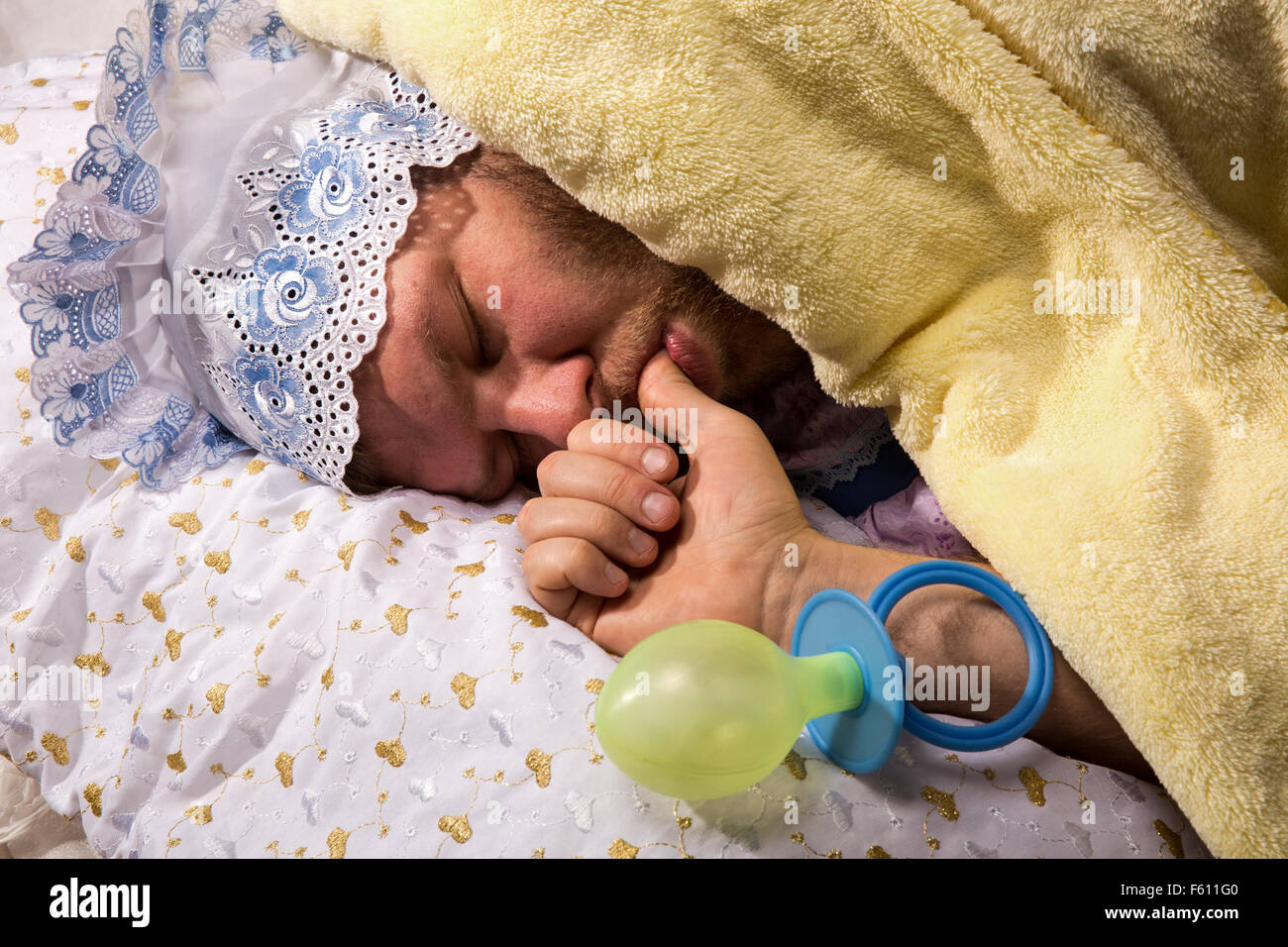 Man weared as baby sleep sucking his thumb Stock Photo