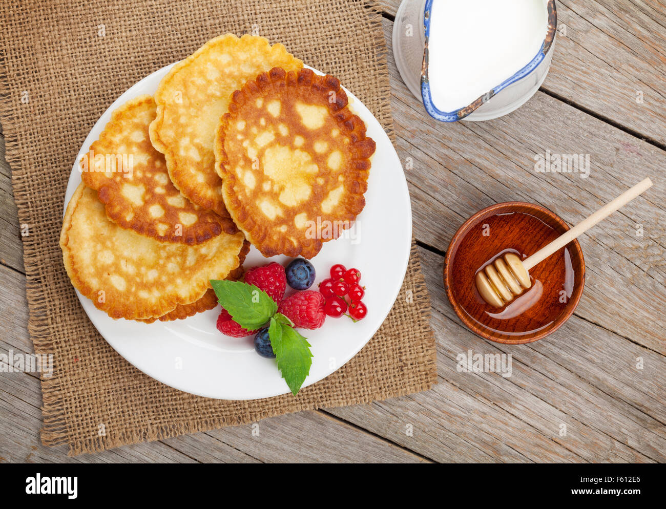 Pancakes Raspberry Blueberries Mint Pancakes with raspberry, blueberry, mint and honey syrup. On wooden ...