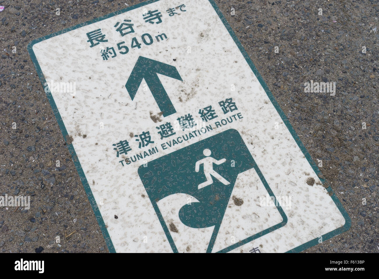 A tsunami evacuation route sign on a pavement in Japan. Stock Photo