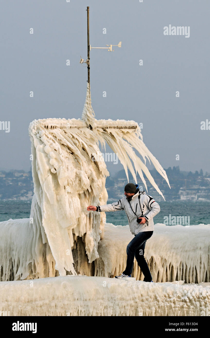 Man and strange ice formation at Port Choiseul during the February 2012 European cold wave in Versoix, Switzerland Stock Photo