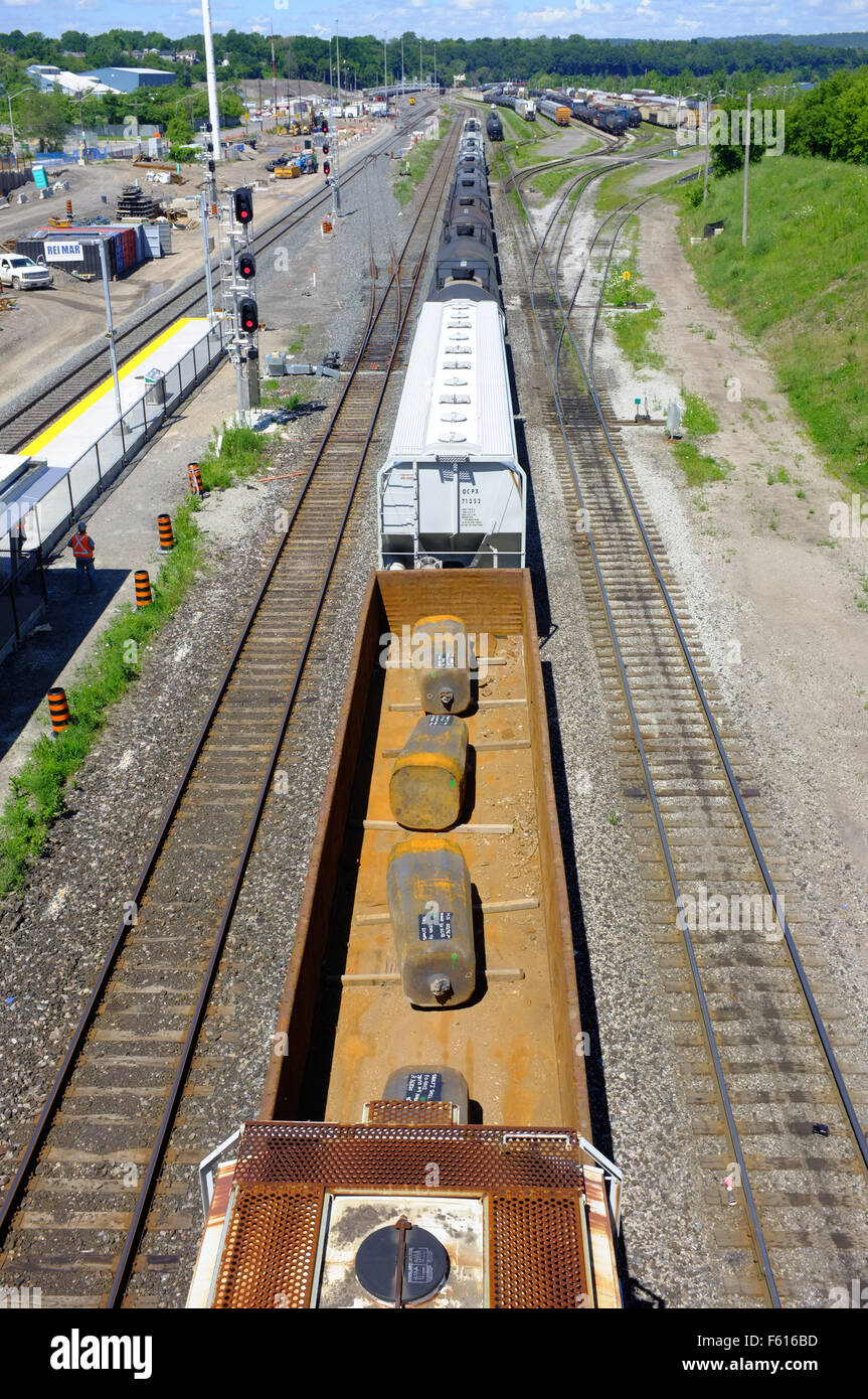 A long freight train passing under a bridge in the Canadian city of