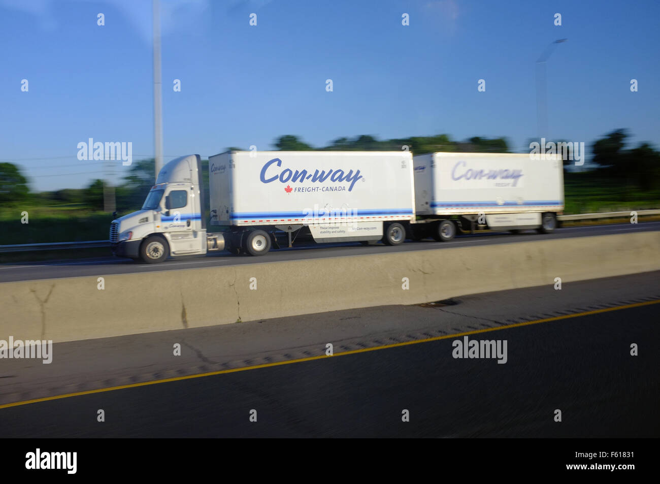 A Canadian lorry pulling two trailers driving on a highway through