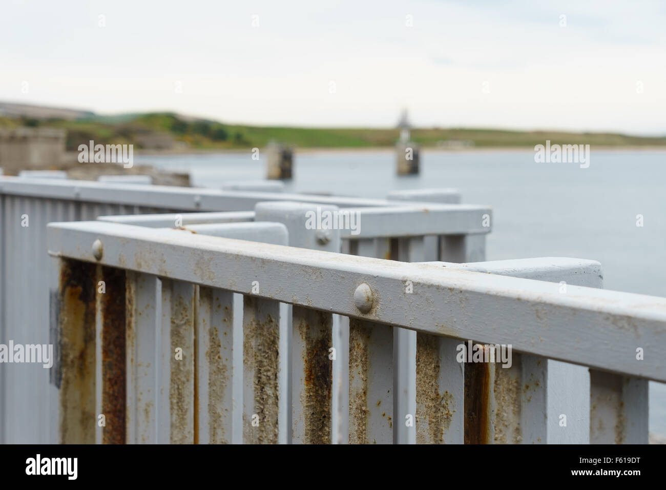 An iron fence along a sea wall coastal walkway in Scotland. Stock Photo