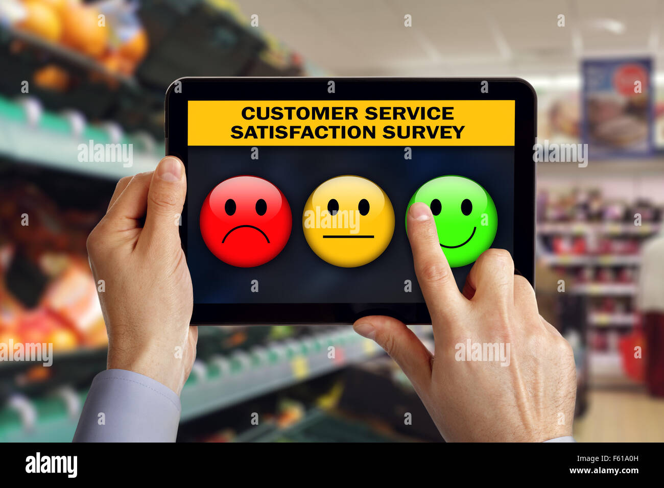 Digital tablet in shop with customer rating a service satisfaction questionnaire survey choosing a happy smiley emoticon Stock Photo