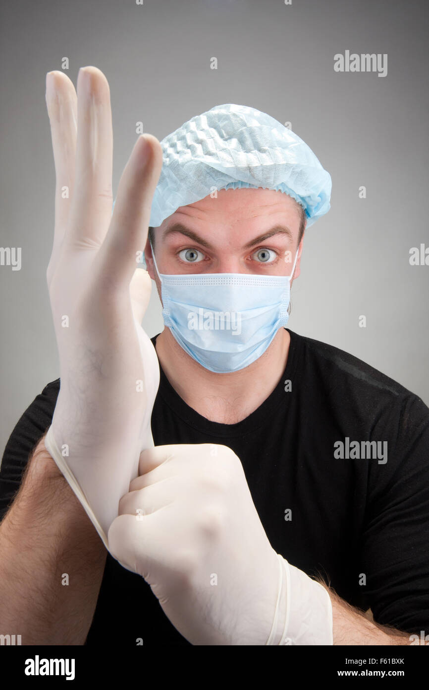 Portrait of surprised dark surgeon wearing gloves Stock Photo