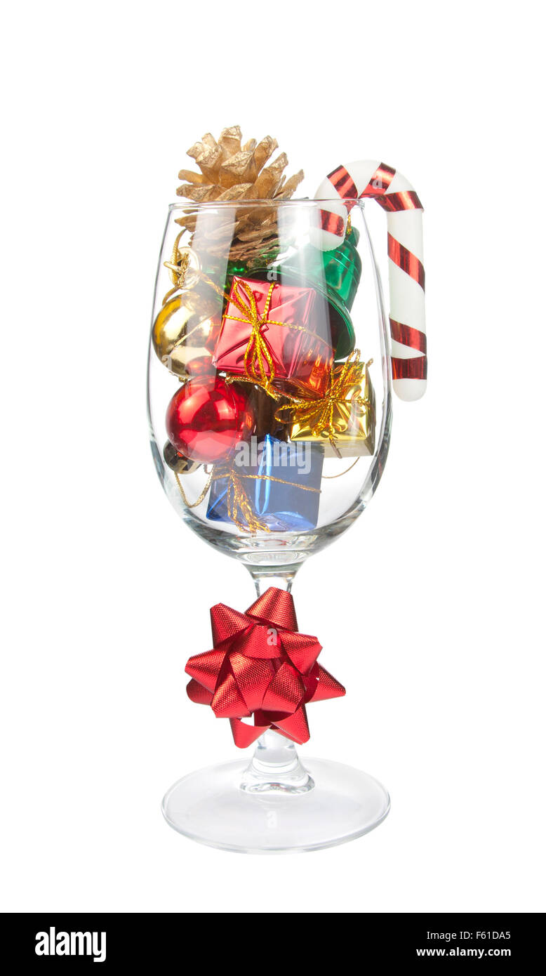 Wine glass full of Christmas decorations. Isolated on white Stock Photo