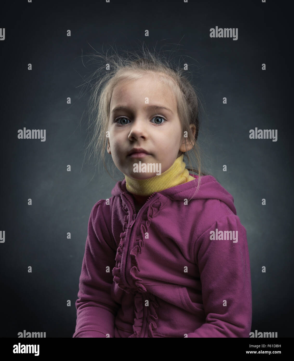 Sad little girl in pink jacket over dark background Stock Photo Alamy