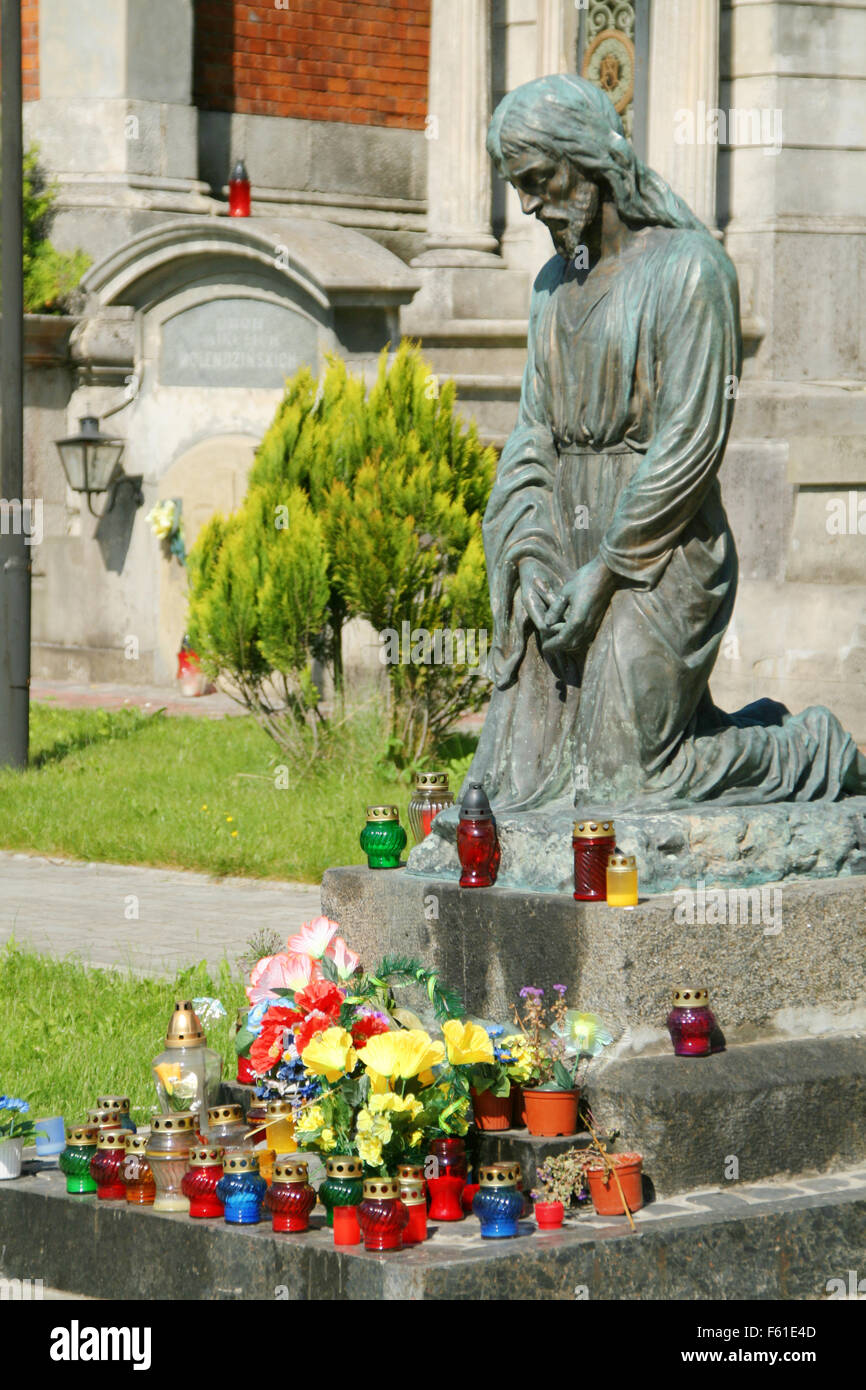 Praying statue and color candles Stock Photo Alamy