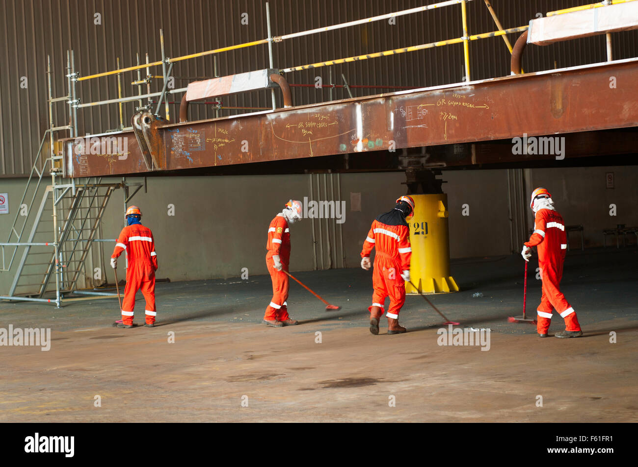 Workers clean up a sand blasting in Karimun Indonesia Stock