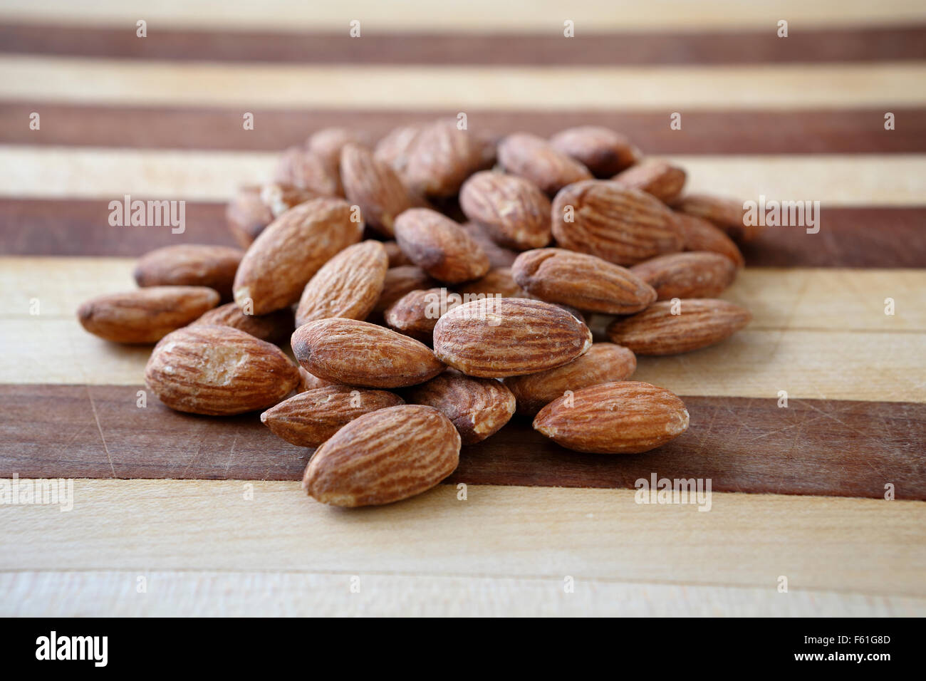 A bunch of almonds on a cutting board ready to become part of a healthy nutritious snack. Stock Photo