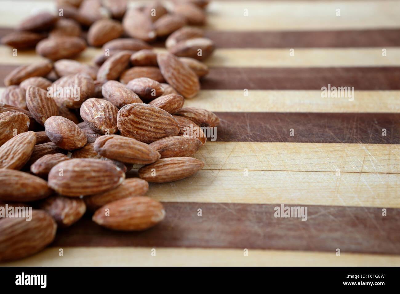 A bunch of almonds on a cutting board ready to become part of a healthy nutritious snack. Stock Photo
